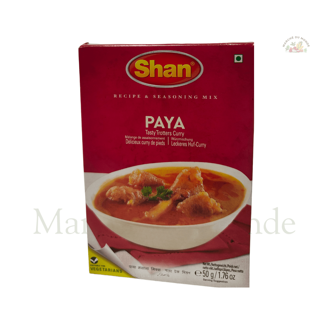 Paquet de Paya Tasty Trotters Curry 50g à côté d’un bol de paya fumant, garni de coriandre et de gingembre frais.