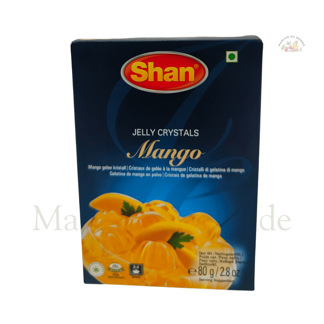 Boîte de Jelly Crystals Mangue 80g à côté d’un dessert gélifié à la mangue servi dans un verre transparent.